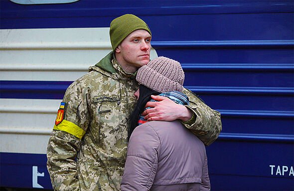 A Ukrainian soldier embracing a loved one at a railway station
